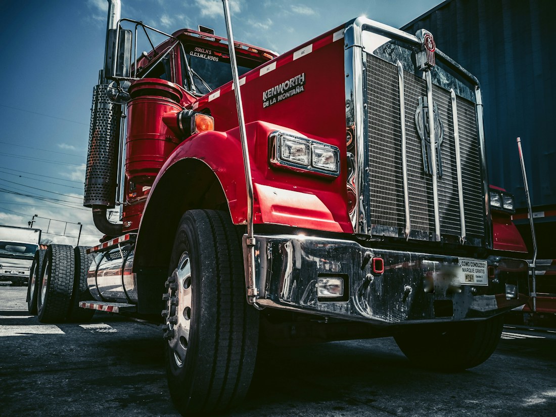 Red and white Kenworth semi truck on the road